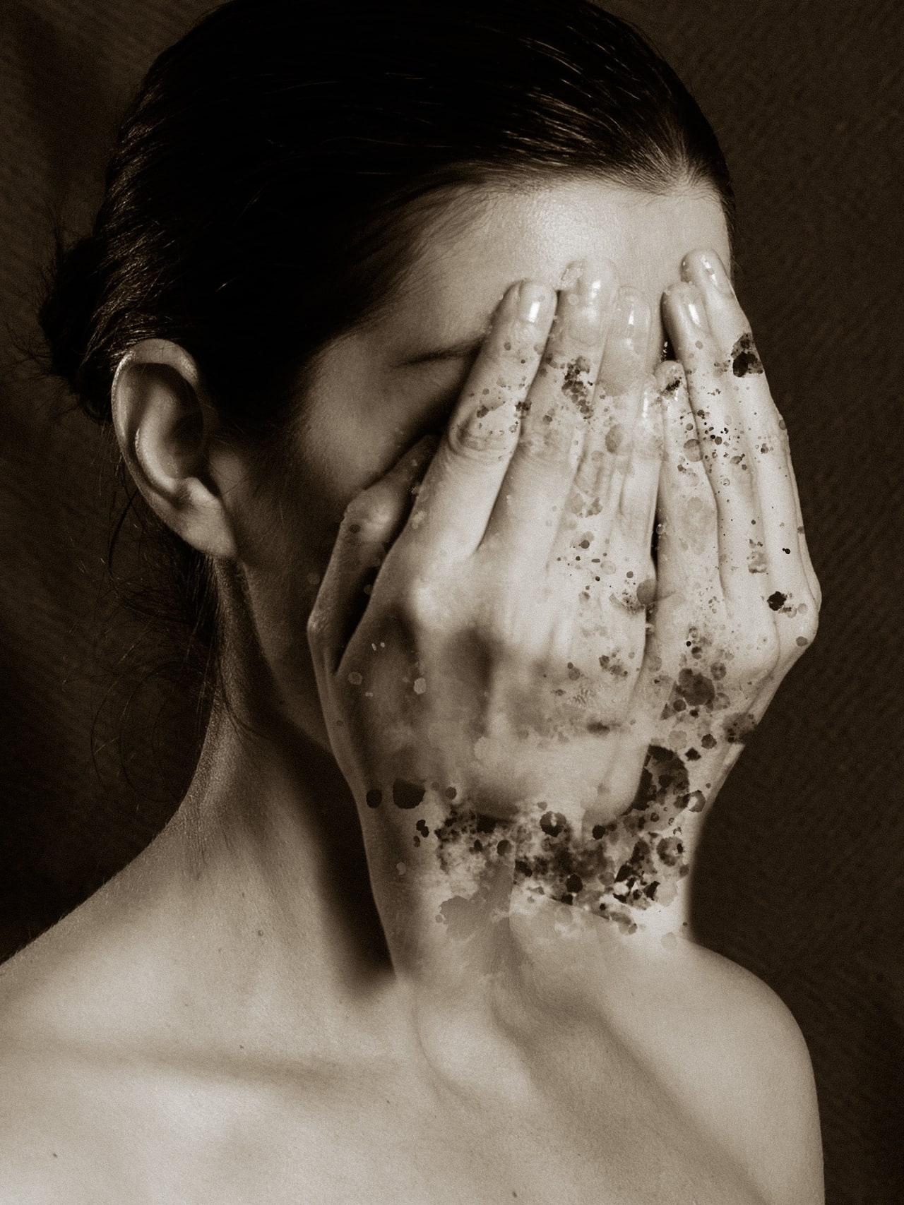 Sepia-toned conceptual self-portrait with layered hands and dissolving textures