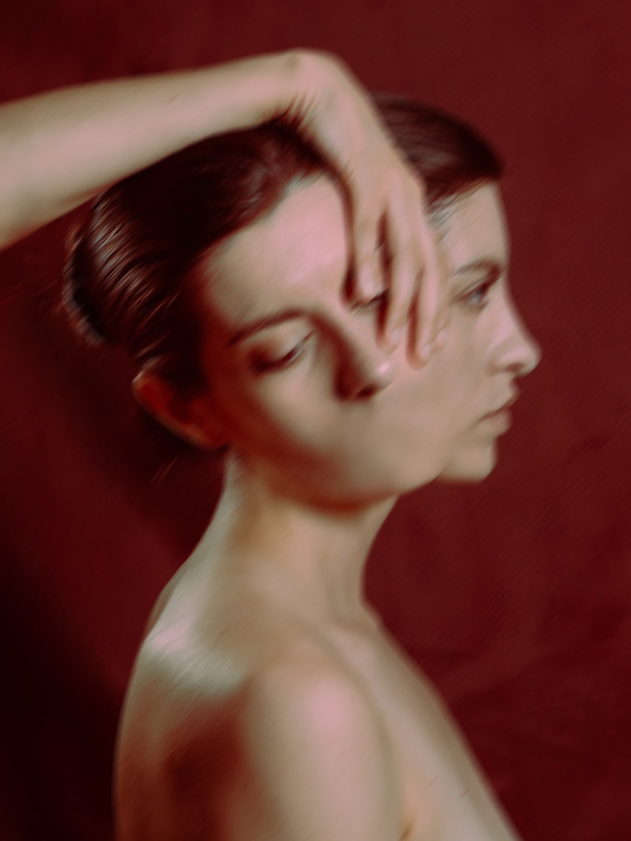 Crimson Reverie I, perfil desenfocado con una mano cruzando el rostro
